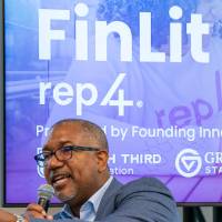 Kala Gibson speaking on stage and pointing at audience